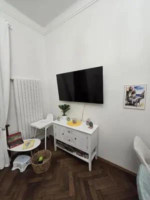 a living room with a tv on a white wall at Get Prague Flat Trojanova in Prague