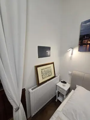 a small room with a bed and a tv at Get Prague Flat Trojanova in Prague