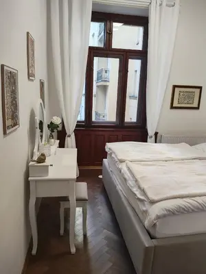 a bedroom with a bed and a table and a window at Get Prague Flat Trojanova in Prague