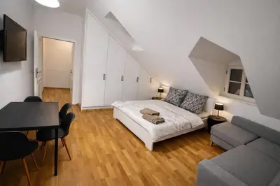 a bedroom with a bed and a couch and a table at Romantic Apt with Secret Terrace - Old Town Prague in Prague