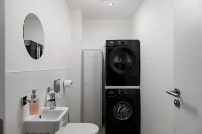 a bathroom with a washing machine and a sink at Modern City Apartment in Prague