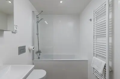 a white bathroom with a shower and a toilet at Modern City Apartment in Prague