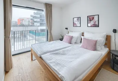 a bedroom with a large white bed with pink pillows at New Modern Apartment with Parking, near Airport in Prague