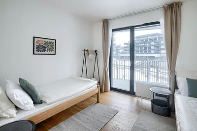 a bedroom with a bed and a large window at New Modern Apartment with Parking, near Airport in Prague
