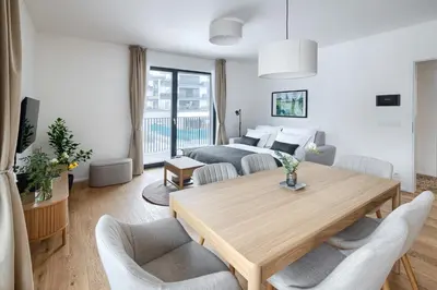 a living room with a table and two beds at New Modern Apartment with Parking, near Airport in Prague