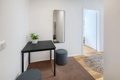 a room with a table and a stool and a mirror at New Modern Apartment with Parking, near Airport in Prague