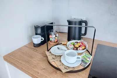 a table with a coffee maker and a bowl of fruit at New Modern Apartment with Parking, near Airport in Prague