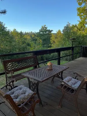 a wooden deck with a table and two chairs on it at 4borovice in Velká Lečice