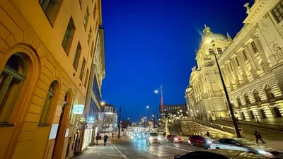 a city street at night with cars and buildings at Night at the Museum in Prague