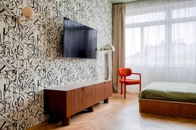 a bedroom with a bed and a tv on a wall at Boutique Studio just 5 min from Wenceslas Square by Gravity Prague in Prague