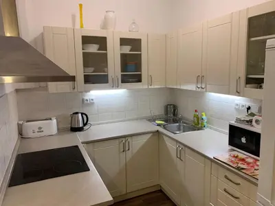 a kitchen with white cabinets and a sink at Palladium family apartment in Prague