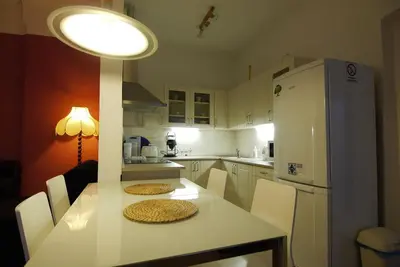 a kitchen with a table with chairs and a refrigerator at Palladium family apartment in Prague