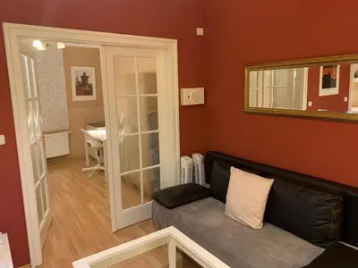 a living room with a couch and a mirror at Palladium family apartment in Prague