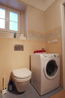 a bathroom with a toilet and a washing machine at Palladium family apartment in Prague