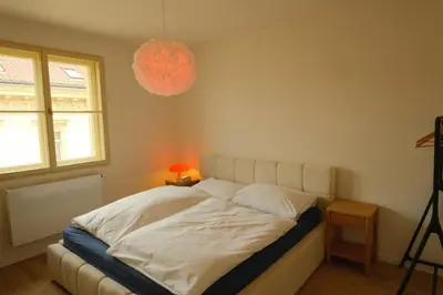 a bedroom with a bed and a chandelier at ChlumovaNest Apartment in Žižkov, close to the city center in Prague