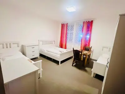 a bedroom with two beds and a table and a window at Big apartment in Brandýs nad Labem in Brandýs nad Labem-Stará Boleslav