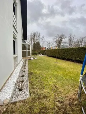 a backyard of a white house with a garden at Villa with swimming pool near Prague in Kamenice