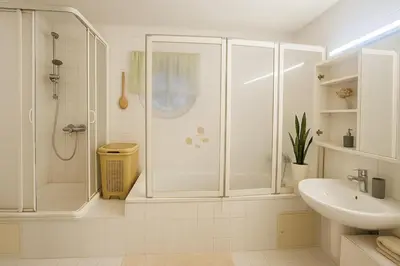 a white bathroom with a shower and a sink at Villa with swimming pool near Prague in Kamenice