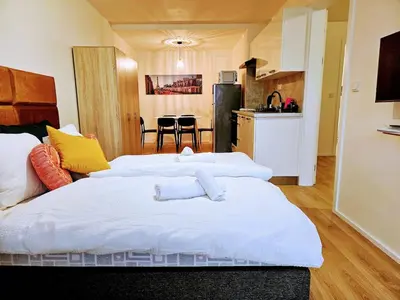 two white beds in a room with a kitchen at PRIVATE GARDEN 2BR PRAGUE APARTMENT for Business & Leisure, FREE PARKING & Gym, by LIVE-INN 2 in Prague