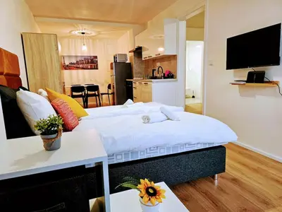 a large bed in a room with a kitchen at PRIVATE GARDEN 2BR PRAGUE APARTMENT for Business & Leisure, FREE PARKING & Gym, by LIVE-INN 2 in Prague
