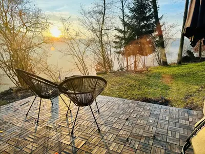 a couple of chairs sitting next to a body of water at Chaloupka v lese u Kutné Hory