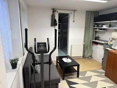 a living room with a treadmill and a table at Cozy place on the edge of Prague in Sibřina
