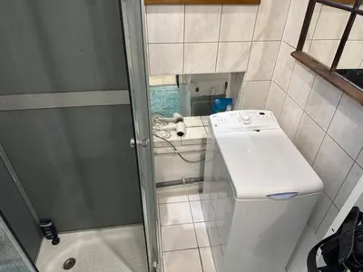 a small bathroom with a shower and a sink at Cozy place on the edge of Prague in Sibřina