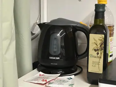 a coffee maker and a bottle of wine on a counter at Cozy place on the edge of Prague in Sibřina