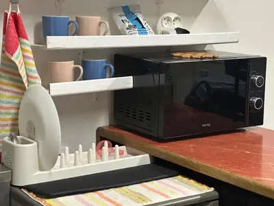 a microwave oven sitting on top of a counter at Cozy place on the edge of Prague in Sibřina