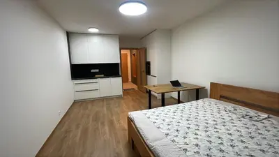 a bedroom with a bed and a table with a laptop at Newly built Studio in Prague Near Metro Haje in Prague