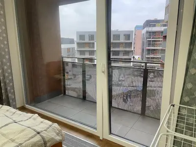 a bedroom with a balcony with a view of a city at Newly built Studio in Prague Near Metro Haje in Prague