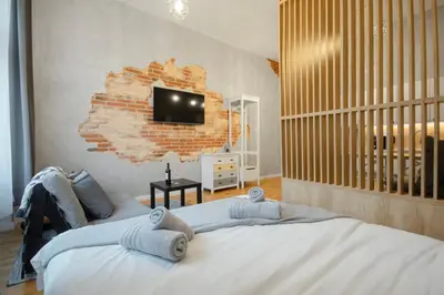 a bedroom with a large bed with a tv on the wall at The new brickhouse apartment in Prague