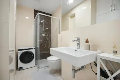 a white bathroom with a sink and a washing machine at The new brickhouse apartment in Prague
