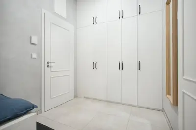 a white bedroom with white cabinets and a door at The new brickhouse apartment in Prague