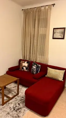 a red couch in a living room with a window at Harrison Homes Apartment 03 - Prague City Centre in Prague