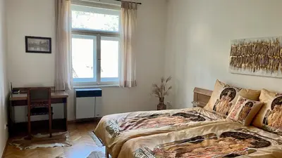 a bedroom with a bed and a desk and a window at Harrison Homes Apartment 03 - Prague City Centre in Prague