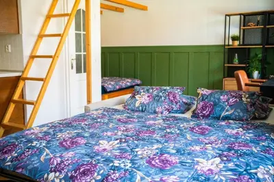 a bedroom with a bed with a floral bedspread and a ladder at Cosy apt in vibrant area 2 metro stops from Prague's hisorical centre in Prague