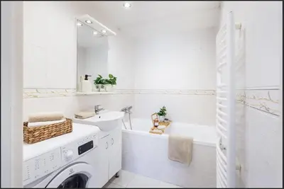 a white bathroom with a washing machine and a sink at Cosy apt in vibrant area 2 metro stops from Prague's hisorical centre in Prague