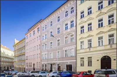 a large building with cars parked in a parking lot at Cosy apt in vibrant area 2 metro stops from Prague's hisorical centre in Prague
