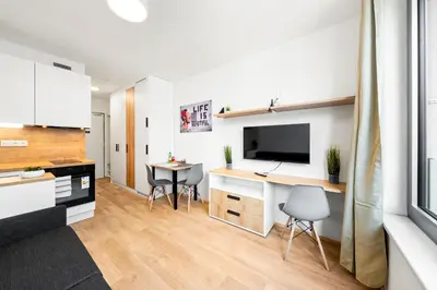 a kitchen with a desk with a tv and two chairs at My Mozart apartments in Prague
