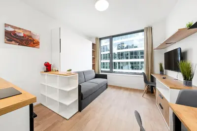 a living room with a couch and a tv at My Mozart apartments in Prague