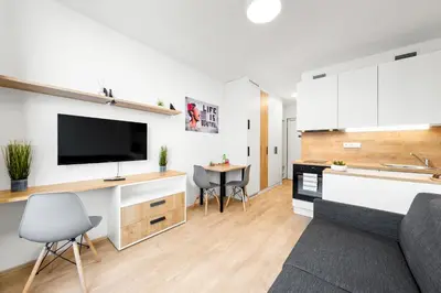 a kitchen and living room with a flat screen tv at My Mozart apartments in Prague