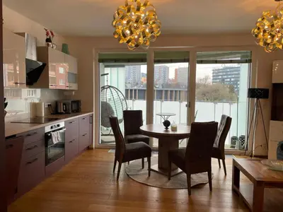 a kitchen and living room with a table and a couch at Appartment Oliva in Prague