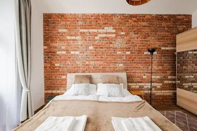 a bedroom with a brick wall and a bed at Apartmán 1min River Dancing House in Prague