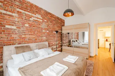 a bedroom with a brick wall and a bed at Apartmán 1min River Dancing House in Prague