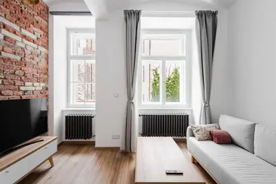 a living room with a couch and a brick wall at Apartmán 1min River Dancing House in Prague