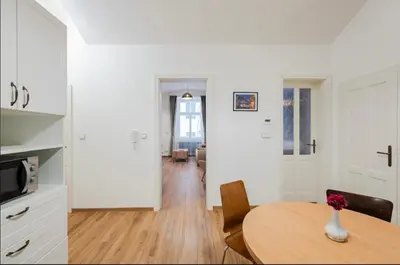 a kitchen and dining room with a table and chairs at Apartmán 1min River Dancing House in Prague