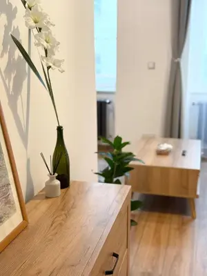 a vase with flowers on top of a wooden cabinet at Apartmán 1min River Dancing House in Prague