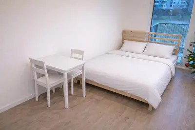 a bedroom with a bed and a table and chair at Modern apartment in the Amadeus residence in Prague