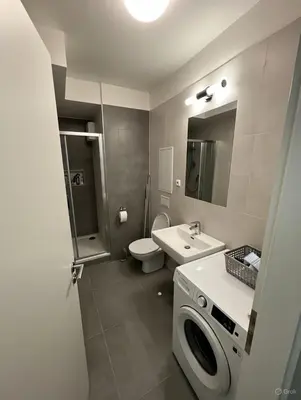 a bathroom with a toilet sink and a washing machine at Modern apartment in the Amadeus residence in Prague